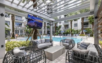A patio with a television and a pool at Mayla Pompano, Pompano Beach